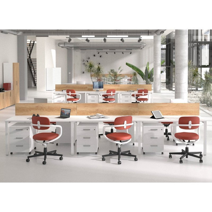 Mesa multipuesto NOVA de OFITRES en sala de reuniones con varias sillas rojas y separador