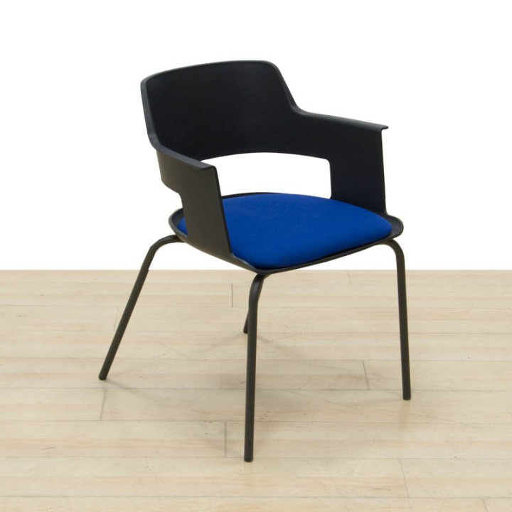 Vista en ángulo de la silla confidente CAPA de FORMA 5 con asiento tapizado azul.