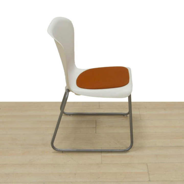 Vista lateral de la silla confidente EASTSIDE-WEST con asiento naranja
