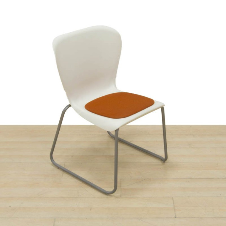 Vista individual de silla EASTSIDE-WEST con asiento naranja y carcasa de PVC blanca